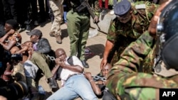 Anti-riot police attempt to break up and arrest protesters braced on the ground in a standoff during protests to demand the release of those allegedly abducted by state security agencies in Nairobi on Dec. 30, 2024.