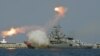 Russian warships fire during a naval parade rehearsal in the Crimean port of Sevastopol, July 25, 2014.