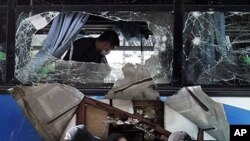 Police investigators search for clues after an explosion of a bus in Manila's main highway in suburban Makati City, Philippines, 25 Jan 2011