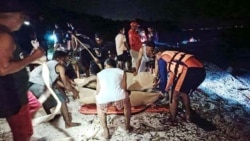 Personel garda pantai dan SAR meletakkan jenazah dua penyelam Rusia di atas tandu di dekat Pulau Verde, di Kota Batangas, selatan Manila, 27 Februari 2025. Keduanya tewas akibat terseret arus deras, dan salah satunya digigit hiu. (Foto: Philippine Coast Guard (PCG) /AFP) 