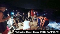 Personel garda pantai dan SAR meletakkan jenazah dua penyelam Rusia di atas tandu di dekat Pulau Verde, di Kota Batangas, selatan Manila, 27 Februari 2025. Keduanya tewas akibat terseret arus deras, dan salah satunya digigit hiu. (Foto: Philippine Coast Guard (PCG) /AFP) 