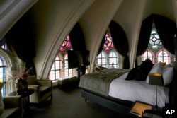 Sunlight filters in through stained glass windows in a guest room at the Martin's Patershof hotel in the center of Mechelen, Belgium, Monday, June 19, 2023. (AP Photo/Virginia Mayo)