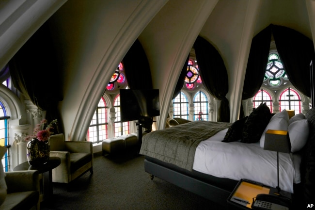 Sunlight filters in through stained glass windows in a guest room at the Martin's Patershof hotel in the center of Mechelen, Belgium, Monday, June 19, 2023. (AP Photo/Virginia Mayo)