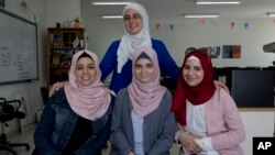 Tamara Awaysa, 17, left, Wassan al-Sayyed,17, center and Massa Halawa,16, right, pose for a photo with their mentor Yamama Shakaa in the West Bank city of Nablus. For the 11th graders from the Israeli-occupied West Bank, the ticket of admission to the World Pitch Summit signals a particularly dramatic leap because of the limited opportunities at home.