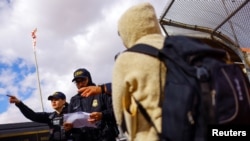 Migrantes que buscan asilo en EEUU y que previamente solicitaron una cita en la aplicación CBP ONE, asisten a su cita en el puente fronterizo internacional Paso del Norte en Ciudad Juárez, México, 18 de enero de 2023.