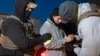 U.S. Immigration and Customs Enforcement officers use a chain to more comfortably restrain a detained person using handcuffs positioned in front, Jan. 27, 2025, in Silver Spring, Maryland.