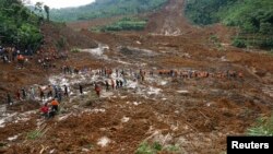 印尼救援人員走過暴雨引發泥石流掩埋一個村莊，搜救失蹤村民。
