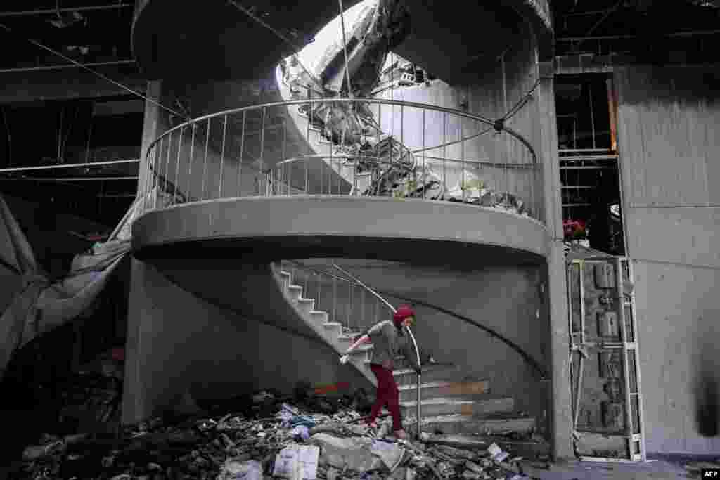 A child walks through debris towards a spiral staircase at the Gaza Municipality&#39;s Rashad al-Shawa Cultural Centre, which was heavily-damaged by Israeli bombardment.