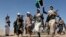 ARCHIVO - Combatientes rebeldes hutíes marchan en muestra de apoyo a los palestinos en la Franja de Gaza y contra los ataques estadounidenses en Yemen, a las afueras de Saná, el 22 de enero de 2024.