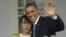 US President Barack Obama, right, waves as he embraces Myanmar democracy activist Aung San Suu Kyi at her residence in Rangoon, Burma, Nov. 19, 2012.