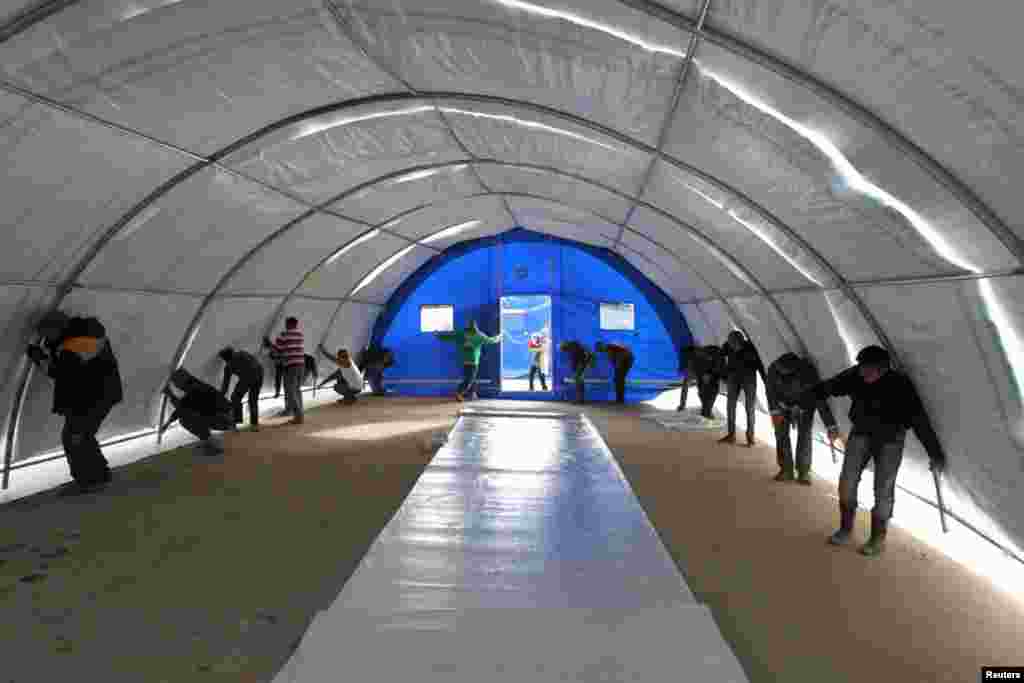 Men build a makeshift school for children at Bab al-Salam refugee camp in Azaz, near the Syrian-Turkish border, January 13, 2013. 