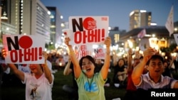 FILE - South Korean people chant slogans during an anti-Japan rally in Seoul, South Korea, Aug. 24, 2019. 