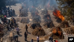 Multiple funeral pyres of victims of COVID-19 burn at a ground that has been converted into a crematorium for mass cremation in New Delhi, India, April 24, 2021.