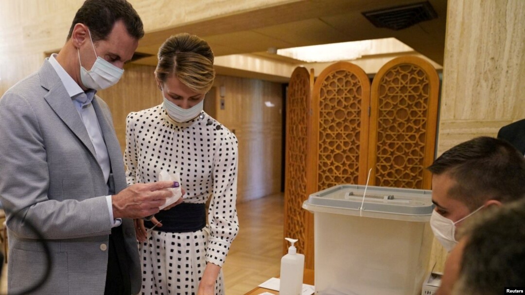 Presiden Suriah Bashar al-Assad dan istrinya Asma saat memasukkan surat suara Pemilu Parlemen di sebuah TPS di Damaskus, Suriah, 19 Juli 2020. (Foto: SANA/Handout via REUTERS)
