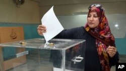 An Omani woman casts her vote at a polling station in Muscat, on October 15, 2011.