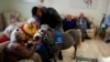 FILE - Stable worker Ali Hussein from Pakistan, 34, holds Calypso, a miniature horse used for therapy programs, during a visit at an elderly care home in Athens, Nov. 22, 2024. 