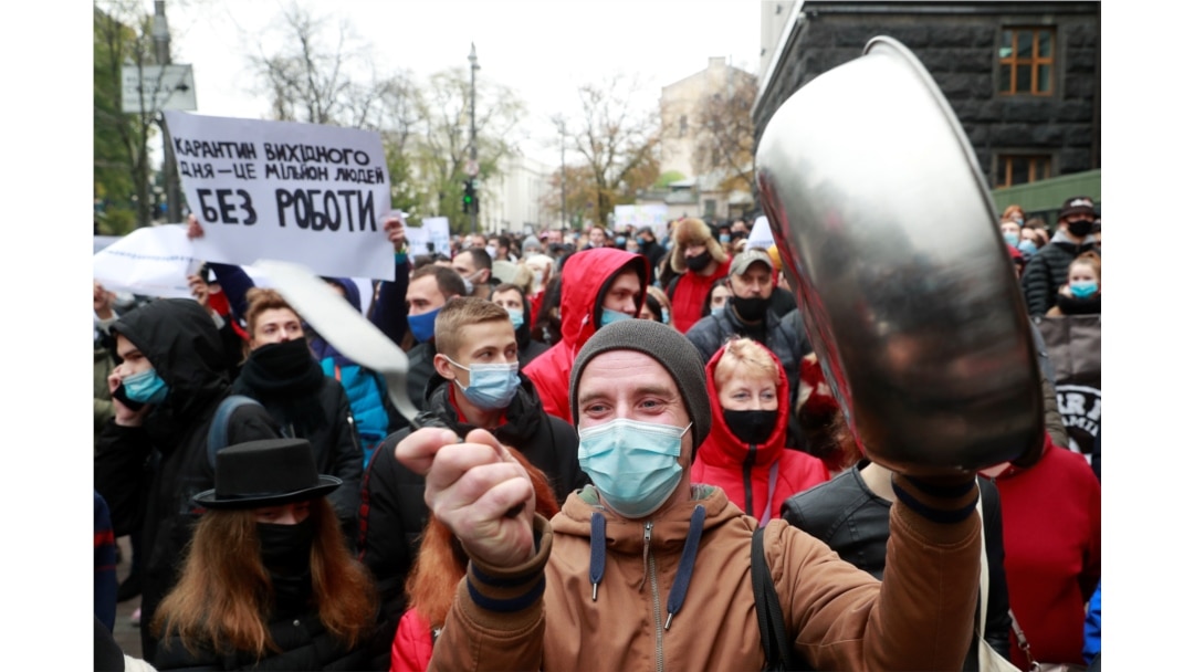 Restaurant workers protest a tighening of coronavirus restictions, including lockdowns on weekends, in Kyiv, Ukraine, Nov. 11, 2020. The sign reads "Weekend lockdowns put a million people out of work."