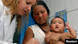 FILE - A health worker vaccinates a boy from the Cambeba tribe against the flu in the center of Brazil's Amazon Basin along the Cueira River.