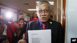 Former party list Congressman and now senatorial candidate Walden Bello holds documents as he arrives at the Commission on Elections seeking to postpone the April 8, 2016 fight between Filipino boxer and senatorial candidate Manny Pacquiao and Timothy Bradley, Feb. 22, 2016 in Manila, Philippines.