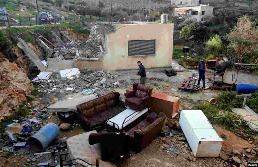 Palestinians check the damages after Israeli forces demolished a house in the village of Al-Walaja near Bethlehem, in the Israeli-occupied West Bank.