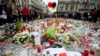 FILE - Three balloons in the colors of the Belgian flag fly as people mourn for the victims of the bombings at the Place de la Bourse in the center of Brussels, Belgium, March 24, 2016. 