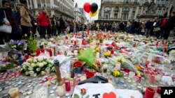 FILE - Three balloons in the colors of the Belgian flag fly as people mourn for the victims of the bombings at the Place de la Bourse in the center of Brussels, Belgium, March 24, 2016. 