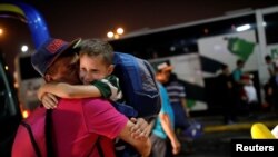 Josmer Rivas, 7, quien viajo en bus desde Caracas con su mamá, abraza a su papá a su llegada a la estación de Guayaquil, Ecuador. Noviembre 10, 2017.