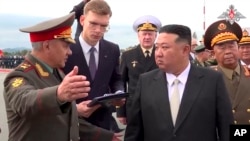 ARCHIVO - En esta imagen, tomada de un video distribuido por el Departamento de Prensa del Ministerio de Defensa de Rusia el 16 de septiembre de 2023, el líder de Corea del Norte, Kim Jong Un (derecha), escucha al ministro ruso de Defensa, Sergei Shoigu (izquierda).