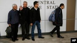 Four protest leaders, from right, Benny Tai Yiu-ting, Chan Kin-man, Chu Yiu-ming and former Cardinal Joseph Zen, walk inside the police station in Hong Kong as they surrender to police Wednesday, Dec. 3, 2014.