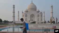 资料照：一名工作人员在印度的泰姬陵前喷洒消毒液。（2020年9月21日）