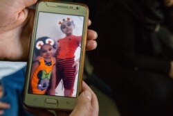 Relatives show pictures of Sara and her younger sister Zainab, before the children were struck recently by a bomb. Oct. 15, 2019, in Qamishli, Syria. (Y. Boechat/VOA)