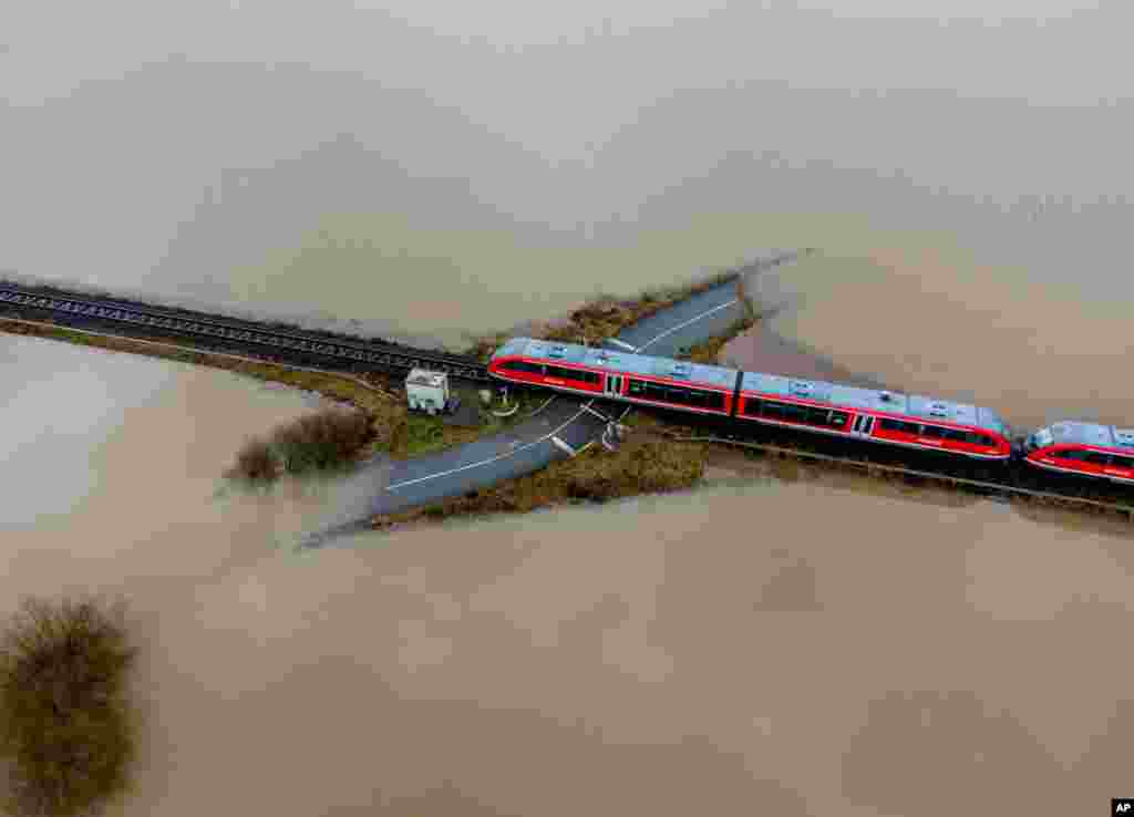 A train passes a rail road crossing that is surrounded by flooding caused by rain and melting snow in Nidderau near Frankfurt, Germany.