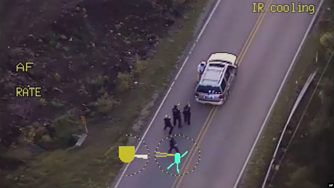 In this image made from a Friday, Sept. 16, 2016 police video, Terence Crutcher, top, is pursued by police officers as he walk to an SUV in Tulsa, Okla.