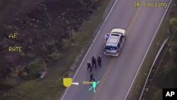 In this image made from a Friday, Sept. 16, 2016 police video, Terence Crutcher, top, is pursued by police officers as he walk to an SUV in Tulsa, Okla.