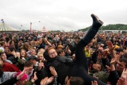 A festivalgoer crowdsurfs on the first day of the Download Festival at Castle Donington, England, June 18, 2021. The three-day music and arts festival was being held as a test event to examine how COVID-19 transmission takes place in crowds.