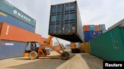 FILE - A mobile crane carries a container at Thar Dry Port in Sanand in the western state of Gujarat, India, Feb. 13, 2017. 