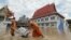 Biksu Buddha menarik gerobak yang membawa karung pasir untuk melindungi sebuah kuil dari banjir di Provinsi Ayutthaya, Thailand, 27 September 2021. (Foto: Dailynews via REUTERS)