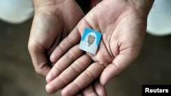 FILE - Irshad Khan, 24, holds a picture of his late father Pehlu, 55, in Jaisinghpur, India, June 2, 2017. 