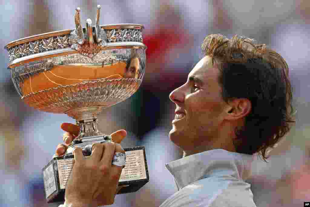 Spain&#39;s Rafael Nadal holds the trophy after winning the final of the French Open tennis tournament against Serbia&#39;s Novak Djokovic at Roland Garros stadium, in Paris. Nadal won in four sets (3-6, 7-5, 6-2, 6-4).