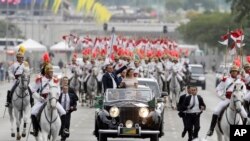 Junto a la primera dama, Michelle Bolsonaro, el presidente de Brasil Jair Bolsonaro saluda a los asistentes a su ceremonia de posesión en Brasilia, Brasil, el martes 1 de enero del 2019