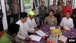 Wakil Gubernur Jawa Timur Saifullah Yusuf (kedua dari kiri) sedang berdialog dengan keluarga calon jamaah haji asal Pasuruan yang tertahan di Filipina, Kamis 25 Agustus 2016 (foto VOA-Petrus Riski).