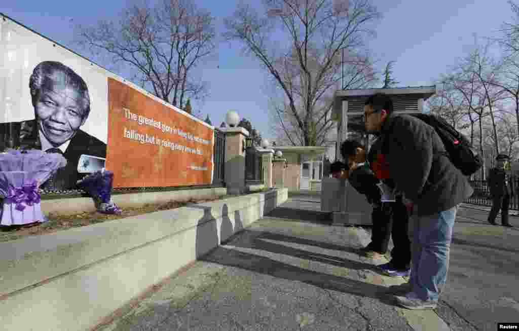 Chinese living in South Africa pay tribute to former South African President Nelson Mandela in front of the South African Embassy in Beijing December 6, 2013. 