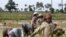 Local Cambodian villagers plant rice in a farm field during the rainy season in Prakar village.