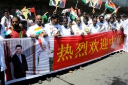 Indians hold a banner welcoming Chinese President Xi Jinping outside the airport in Chennai, India, Oct. 11, 2019.