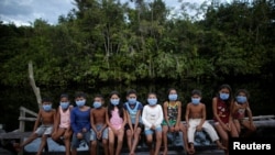 Children wearing protective face masks as healthcare workers visit to check on residents during the COVID-19 outbreak in the municipality of Portel, Marajo island, Para state, Brazil, June 13, 2020. REUTERS/Ueslei Marcelino