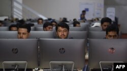 FILE - Independent Election Commission workers sit at computer terminals while election information from all over the country is gathered at a data center in Kabul, Oct. 2, 2019. 