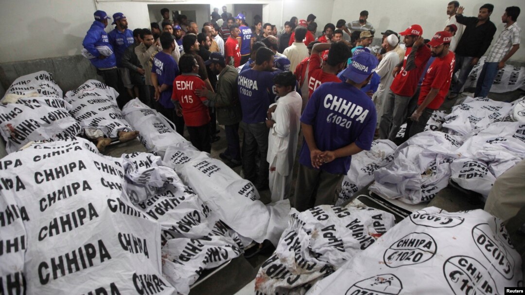 Rescue workers and residents gather to identify relatives at a morgue after a bomb blast in a residential area in Karachi March 3, 2013.