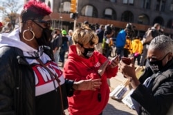 미국 대통령 선거 다음날인 4일 디트로이트에서 열린 조 바이든 민주당 후보 지지 집회 참가자들이 스마트폰으로 개표 현황을 확인하고 있다.