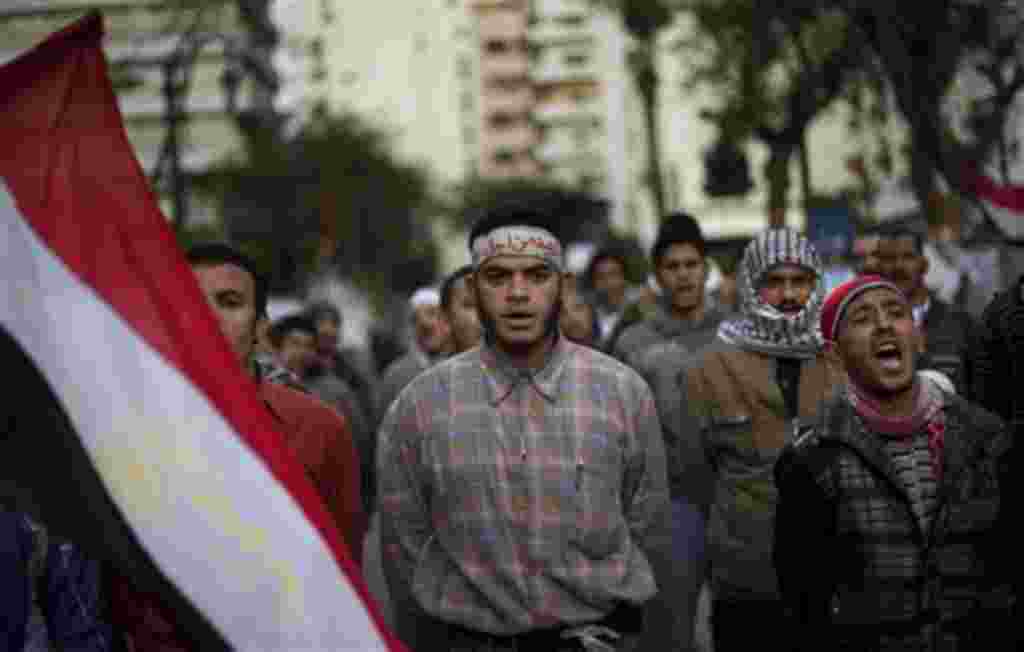Anti-government protesters shout slogans as they line up after spending the night in front of the Egyptian Parliament in Cairo, Egypt, Thursday, Feb. 10, 2011. Around 2,000 protesters waved huge flags outside the parliament, several blocks from Tahrir Squ