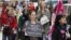An activist holds a sign as she attends a demonstration a day after the French Constitutional Council decided the immediate repeal of the law on sexual harassment, in Paris, May 5, 2012. 